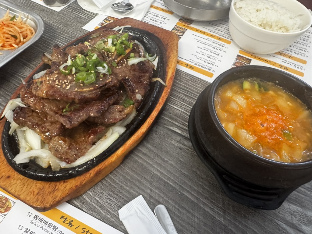 한인 식당 테이블 위의 불고기, 된장찌개, 공깃밥과 한·영 병기 메뉴판
